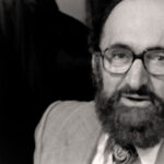 Still from the film "Democracy on Trial" featuring a black and white headshot of Henry Morgentaler, a middle aged white man with a beard and glasses.