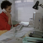 Still from the film "The Glass Ceiling" featuring one of the subjects, a young black woman, working as a receptionist.