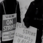 Still from the film "The Fleck Women" featuring a blurry black and white archival photograph of two Fleck strikers holding signs.