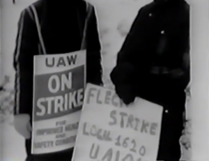 Still from the film "The Fleck Women" featuring a blurry black and white archival photograph of two Fleck strikers holding signs.