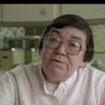 Still from the film "A Writer in the Nuclear Age" featuring Margaret Laurence, an older white woman with short brown hair and glasses, speaking to the camera.