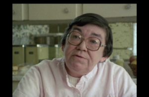 Still from the film "A Writer in the Nuclear Age" featuring Margaret Laurence, an older white woman with short brown hair and glasses, speaking to the camera.