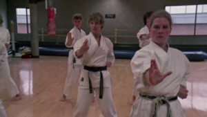 Still from the film "Spirit of the Kata" depicting four white women doing karate in a gym.