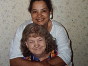 Still from the film "Motherland: Tales of Wonder" featuring Florence Clark, a biracial woman who is one of the subjects of the film, hugging her mother.