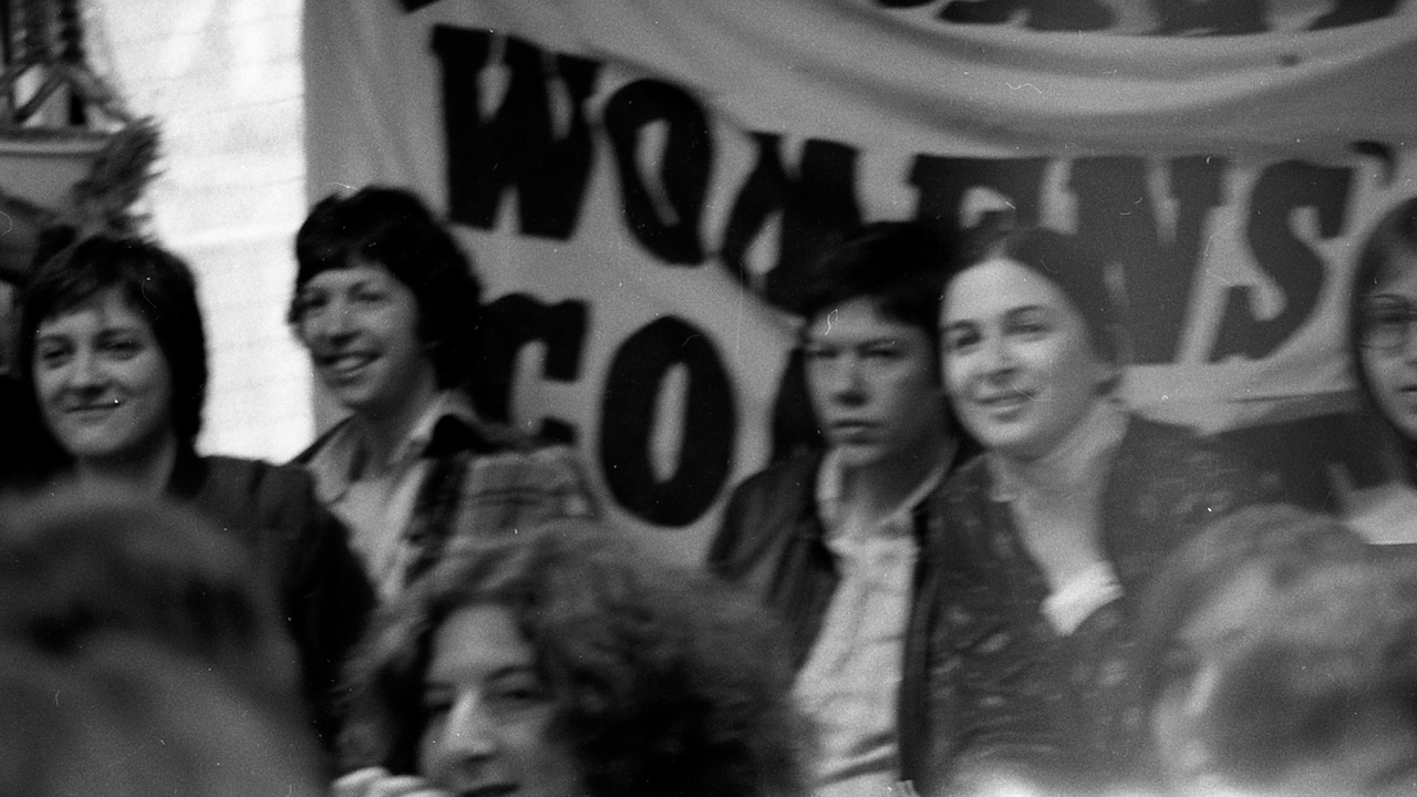 historical photograph of a group of women in front of a banner at an International Women's Day celebration