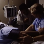 Still from the film "The Right to Care" featuring a nurse and a doctor treating a patient on a hospital bed.