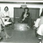 Group of women sitting in a classroom with notebooks.