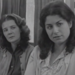 Black and white still from the film "Maria" featuring Maria and her mother talking to a union organizer.