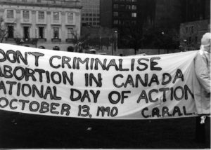 The CARAL banner highlights the National Day of Action on October 13,1990, and the slogan "Don't Criminalise Abortion in Canada." Women's groups across Canada were asked to produce a protest banner that would become part of a huge banner in Ottawa. The goal was to show the strength and solidarity of women during the Third Commonwealth meeting of Ministers Responsible for Women’s Affairs in October 1990.