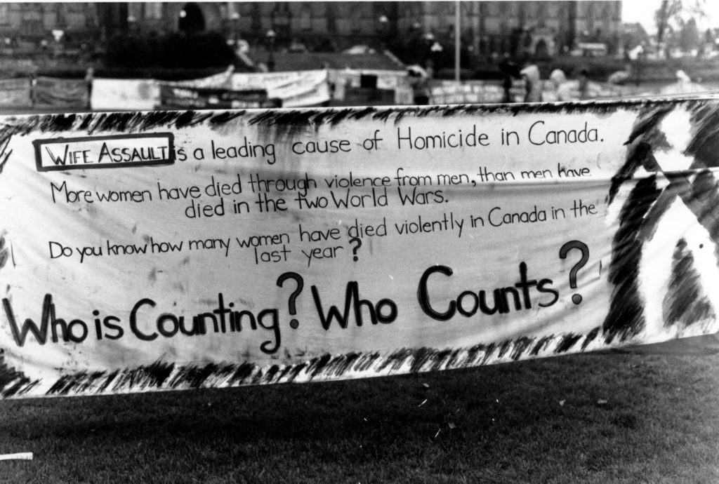 This banner was part of the Banner Project and focuses on the extent of wife assault and homicide in Canada. The Banner Project asked women's groups across Canada to produce a protest banner that would become part of a huge banner in Ottawa. The goal was to show the strength and solidarity of women during the Third Commonwealth meeting of Ministers Responsible for Women’s Affairs in October 1990.