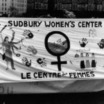 Photo of the Sudbury Women's Centre/Le centre des femmes section of the Banner Project. Women's groups across Canada were asked to produce a protest banner that would become part of a huge banner in Ottawa. The goal was to show the strength and solidarity of women during the Third Commonwealth meeting of Ministers Responsible for Women’s Affairs in October 1990.