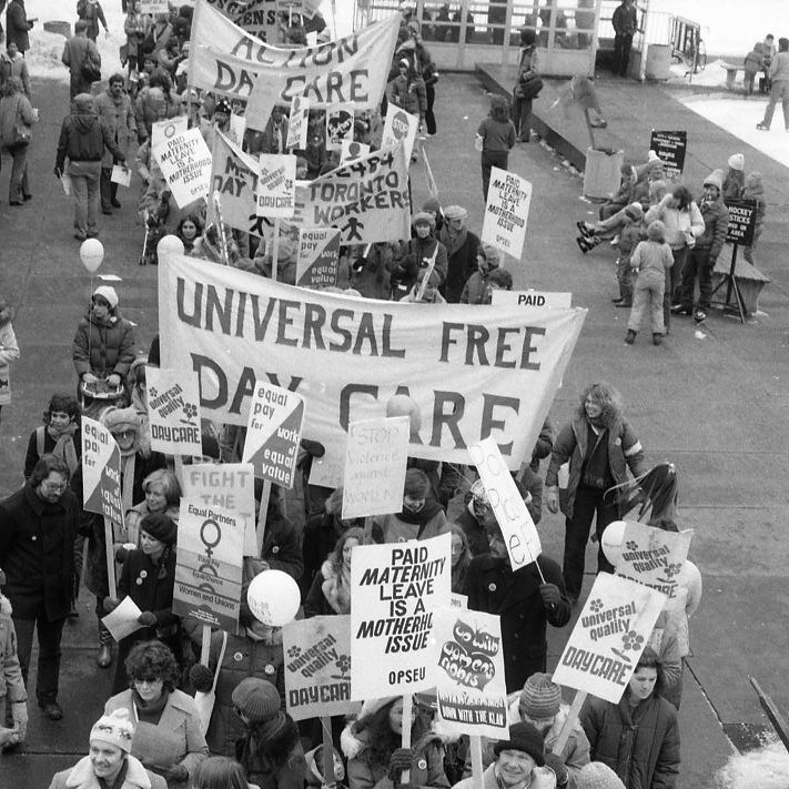 Action Daycare and other childcare activists join the 1983 International Women's Day March in Toronto. Signs call for universal quality daycare and paid maternity leave.