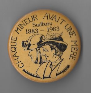 This is the French version of the button created by Sudbury Women’s Centre for Sudbury’s centennial celebration in 1983. It was part of their response to the official logo which featured two miners to honour the role of working men in building the community, and was aimed at highlighting the significant, but largely unpaid and invisible roles played by women. The Sudbury Women’s Centre group claimed Mother’s Day for an event that would feature women’s contributions to Sudbury’s social history. The project, which included a large collection of photos and interviews, attracted a lot of interest. More than 450 people attended the Miners Mother’s Day Tea itself.