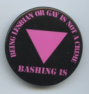 This pin responded to the ongoing acts of physical violence, intimidation, and harassment against lesbians and gays, noting that being lesbian and gay is not a crime while "bashing" is.