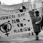 The theme of the Toronto International Women's Day March was Say No to Racism. The photo shows the Native Women's Resource Centre banner and contingent, as well as placards highlighting the impact of racism and colonialism on children. Photograph by Diana Meredith.