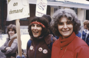 Shelley Glazer and Sheila Miller walk with Free Abortion on Demand placard at 1982 International Women's Day March in Toronto.