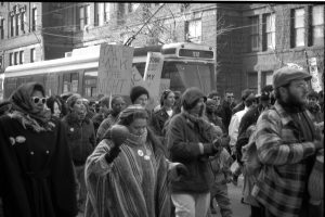 Photo from the 1990 International Women's Day March in Toronto shows demonstrator with Take Back the Night placard.