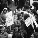 A woman at 1983 International Women's Day March in Toronto carries Bread and Roses sign.