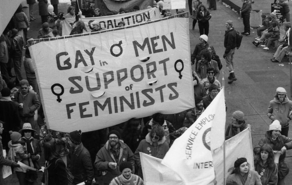 This photo captures the Gay Men in Support of Feminists at the 1983 International Women's Day March in Toronto.