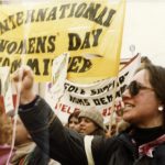 A photo of the International Women's Day Committee banner and contingent at a Toronto IWD march.