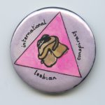 This undated button shows two women in a pink triangle embracing, together with the words "international lesbian conspiracy."