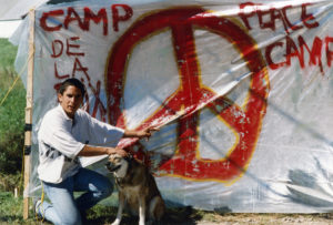 This photo is one of a number taken at the Oka Peace Camp set up in July 1990 in solidarity with the Mohawks of Kanehsatake who rose up in defense of their ancestral lands after the Oka Golf Club proposed an extension and the building of luxury condos over a Mohawk ancestral graveyard in the sacred wooded area known as “The Pines”. This land had never been ceded. In early July, after the Mohawks refused to end their non-violent occupation of the area or to take down the barricade, the Sûreté du Québec (Quebec police) moved in resulting in a violent confrontation. Later, the Canadian army was called in. Mohawk women, including Ellen Gabriel, played a central role in the uprising, which lasted for 78 intense days (July 11 – September 26, 1990). In the end, the golf course was not extended, and the condos were not built. But the larger issues of land sovereignty have never been resolved.