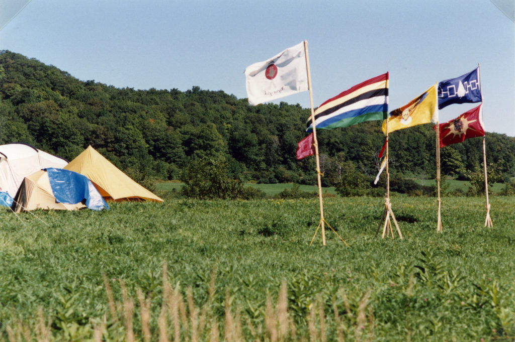 This photo is one of a number taken at the Oka Peace Camp set up in July 1990 in solidarity with the Mohawks of Kanehsatake who rose up in defense of their ancestral lands after the Oka Golf Club proposed an extension and the building of luxury condos over a Mohawk ancestral graveyard in the sacred wooded area known as “The Pines”. This land had never been ceded. In early July, after the Mohawks refused to end their non-violent occupation of the area or to take down the barricade, the Sûreté du Québec (Quebec police) moved in resulting in a violent confrontation. Later, the Canadian army was called in. Mohawk women, including Ellen Gabriel, played a central role in the uprising, which lasted for 78 intense days (July 11 – September 26, 1990). In the end, the golf course was not extended, and the condos were not built. But the larger issues of land sovereignty have never been resolved.