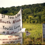 This photo is one of a number taken at the Oka Peace Camp set up in July 1990 in solidarity with the Mohawks of Kanehsatake who rose up in defense of their ancestral lands after the Oka Golf Club proposed an extension and the building of luxury condos over a Mohawk ancestral graveyard in the sacred wooded area known as “The Pines”. This land had never been ceded. In early July, after the Mohawks refused to end their non-violent occupation of the area or to take down the barricade, the Sûreté du Québec (Quebec police) moved in resulting in a violent confrontation. Later, the Canadian army was called in. Mohawk women, including Ellen Gabriel, played a central role in the uprising, which lasted for 78 intense days (July 11 – September 26, 1990). In the end, the golf course was not extended, and the condos were not built. But the larger issues of land sovereignty have never been resolved.