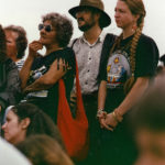 This photo is one of a number taken at the Oka Peace Camp set up in July 1990 in solidarity with the Mohawks of Kanehsatake who rose up in defense of their ancestral lands after the Oka Golf Club proposed an extension and the building of luxury condos over a Mohawk ancestral graveyard in the sacred wooded area known as “The Pines”. This land had never been ceded. In early July, after the Mohawks refused to end their non-violent occupation of the area or to take down the barricade, the Sûreté du Québec (Quebec police) moved in resulting in a violent confrontation. Later, the Canadian army was called in. Mohawk women, including Ellen Gabriel, played a central role in the uprising, which lasted for 78 intense days (July 11 – September 26, 1990). In the end, the golf course was not extended, and the condos were not built. But the larger issues of land sovereignty have never been resolved.