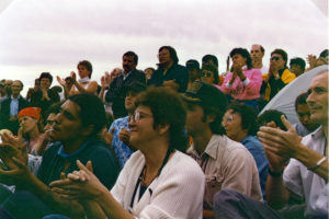 This photo is one of a number taken at the Oka Peace Camp set up in July 1990 in solidarity with the Mohawks of Kanehsatake who rose up in defense of their ancestral lands after the Oka Golf Club proposed an extension and the building of luxury condos over a Mohawk ancestral graveyard in the sacred wooded area known as “The Pines”. This land had never been ceded. In early July, after the Mohawks refused to end their non-violent occupation of the area or to take down the barricade, the Sûreté du Québec (Quebec police) moved in resulting in a violent confrontation. Later, the Canadian army was called in. Mohawk women, including Ellen Gabriel, played a central role in the uprising, which lasted for 78 intense days (July 11 – September 26, 1990). In the end, the golf course was not extended, and the condos were not built. But the larger issues of land sovereignty have never been resolved.