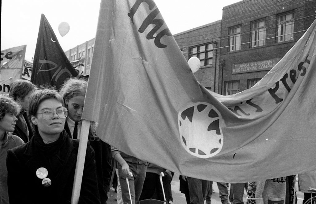 Members of The Women's Press carry a banner at the October 22, 1983 “Refuse the Cruise” protest organized by the Toronto Disarmament Network (TDN) and the Against Cruise Testing Coalition (ACT). The International Women’s Day Committee was one of many groups to support the march.