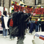 Marchers at the 1990 International Women's Day March in Toronto carry signs outside Queen's Park calling for settlement of Native Land claims and an end to the Gulf War.