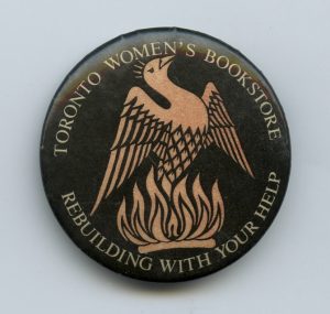 The button shows the phoenix of the bookstore rising from the ashes after the 1983 firebombing of the Morgentaler abortion clinic. The Toronto Women's Bookstore was in the same building and was severely damaged by the attack.