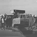 This photo of the Abortion Caravan during stop in Calgary features Cathy Walker standing in the door of the van, with Charlotte Bedard's truck and camper in the background.