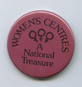 A button defending women's centres after major funding cuts in 1990.