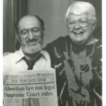 Norma Scarborough and Henry Morgentaler hold a copy of The Toronto Star with front-page headlines announcing the historic Supreme Court decision taken on January 28, 1988, stating that Canada's abortion law is not legal.