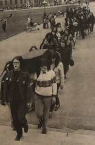 Protesters wearing headscarves climb stairs at the Parliament Building carrying a coffin during the outside protest on May 11th. Charlotte Bedard is the first pallbearer on the right.