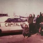 During a stop en route to Ottawa, members of the Abortion Caravan raise their fists for a photo alongside Betsy Wood's convertible with the slogan "Smash Capitalism" painted on the side panel.