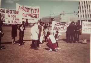 Members of the Abortion Caravan prepare for a Guerrilla Theatre skit during a stop on the Prairies.