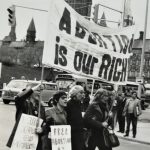 Vancouver women lead the Ottawa march down Wellington Street with a banner proclaiming "Abortion is Our Right". Gwen Hauser is on the right in the picture.