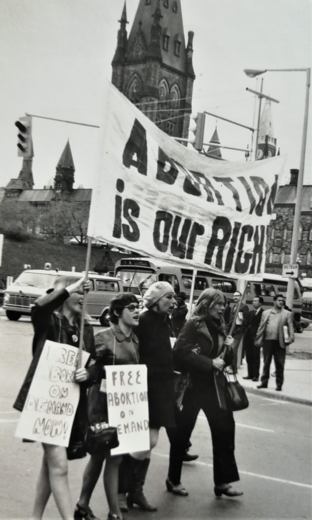 Vancouver women lead the Ottawa march down Wellington Street with a banner proclaiming "Abortion is Our Right". Gwen Hauser is on the right in the picture.