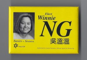 This a button to elect Winnie Ng, a long-time labour, anti-racist, and social justice activist running in 1993 for the federal New Democratic Party in the Toronto riding Trinity Spadina.