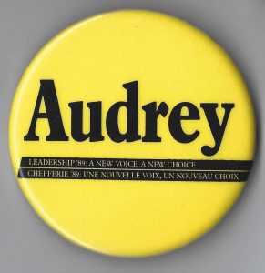 Audrey McLaughlin was elected leader of the federal New Democratic Party in 1989, becoming the first female leader of a political party represented in the House of Commons of Canada. She continued as leader until 1995. This button with the slogan "Leadership '89: A New Voice, A New Choice/Chefferie '89: une nouvelle voix, un nouveau choix" is from her leadership campaign.