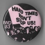 This button for International Women's Day 1983 features the slogan "Hard Times Won't Stop Us".