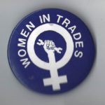 This button for women in trades features the woman symbol with an upraised fist holding a wrench.