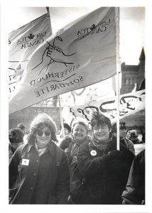 Judy Rebick, Past President of NAC; Cheryl Kryzaniwsky, CAW Council; and Peggy Nash, Assistant to CAW President join Canadian Auto Worker contingent at 1996 IWD March in Toronto.