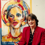 This is an undated photo of Canadian Auto Workers (CAW) activist and feminist, Peggy Nash. Peggy is sitting in front of the powerful CAW Women Unite Sisterhood Solidarity painting.