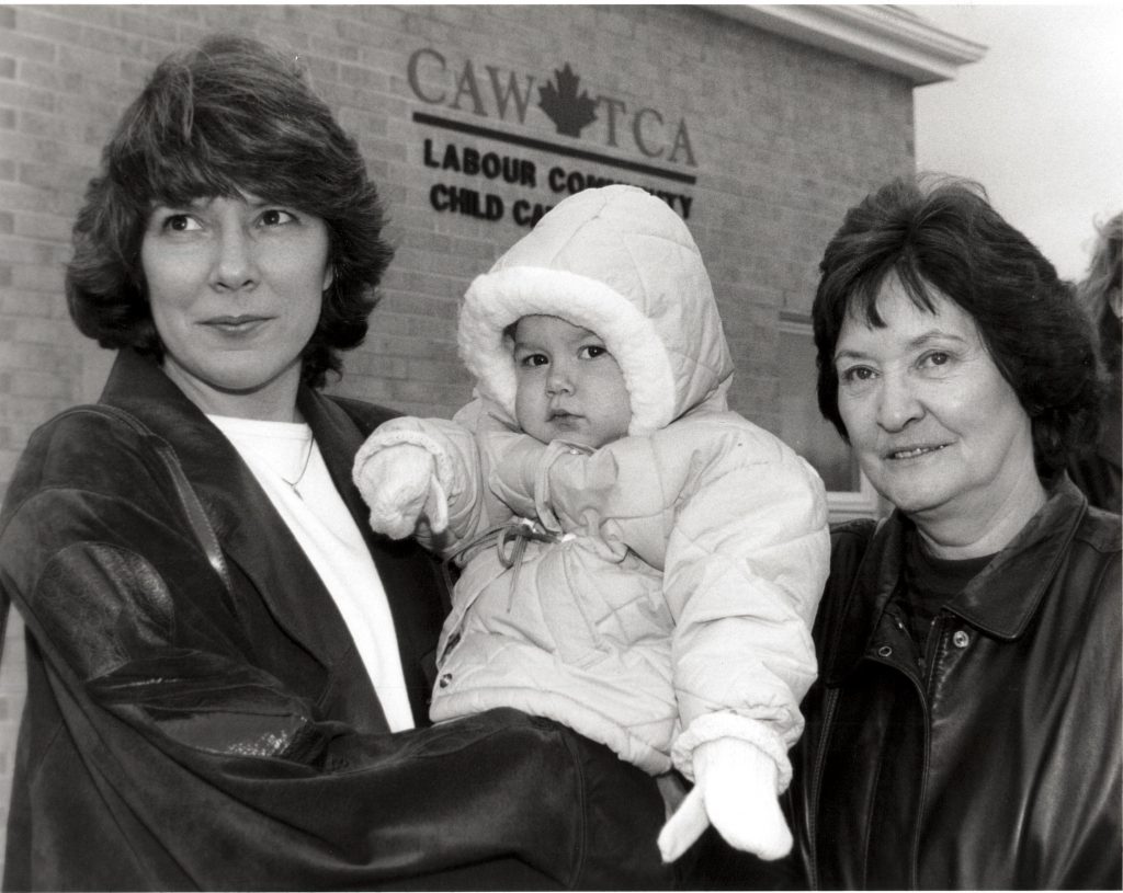 The photo was taken outside the CAW labour community childcare centre in Windsor. The Centre was opened in 1989 after the Canadian Auto Workers bargained with Chrysler, General Motors, and Ford for financial support for childcare centres. The intention was to provide quality, not-for-profit care to support parents and to act as a model for a genuine child care strategy.