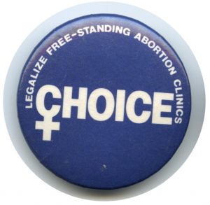 Button distributed by the Ontario Coalition for Abortion Clinics to show support for the legalization of free-standing abortion clinics.