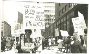 This is one of several photos taken at a protest organized by the New Feminists on May 1 1969 outside the Maclean's magazine office after it published a review of Lionel Tiger's book Men in Groups in which he theorizes about differences in male and female roles and male superiority.